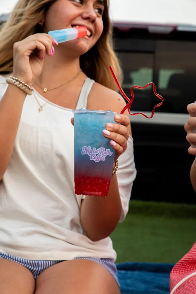 Guest holding a Night Roller drink at a tailgate-style setup