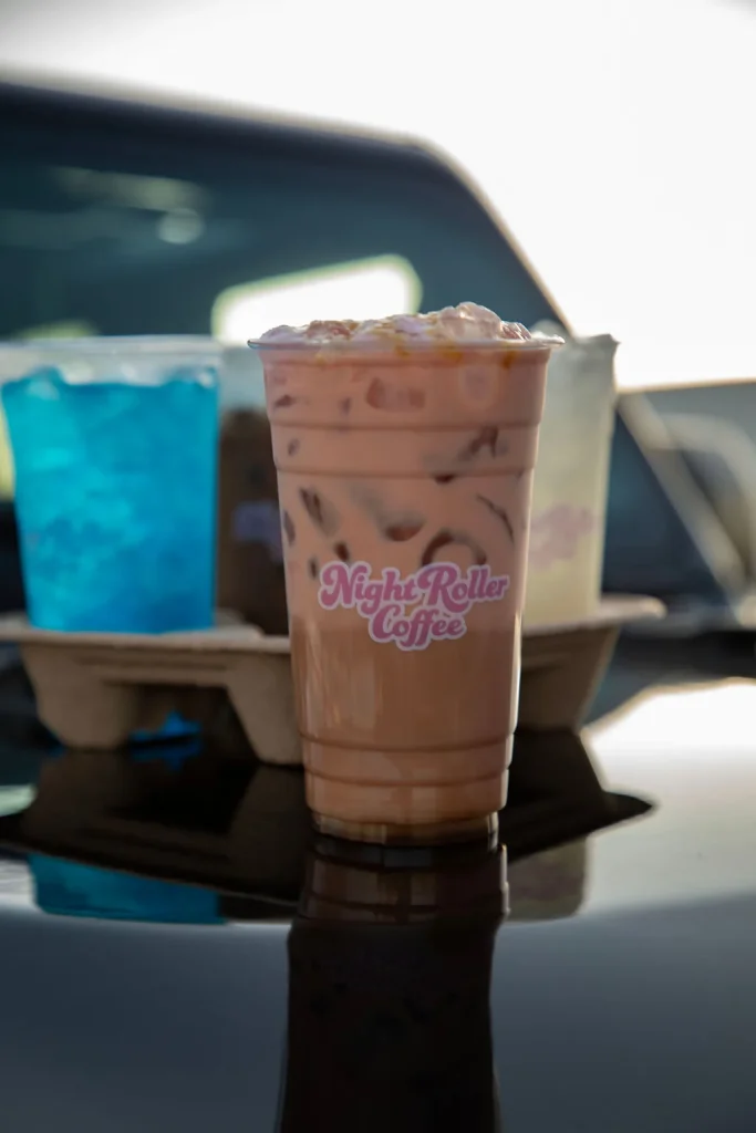 Iced coffee and blue drink on a car dashboard